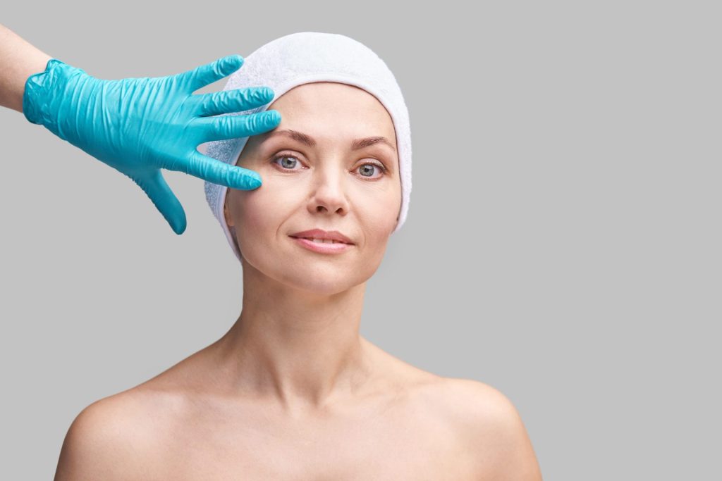 Profissional realizando aplicação de bioestimulador de colágeno no rosto de paciente na Clínica Muglia.