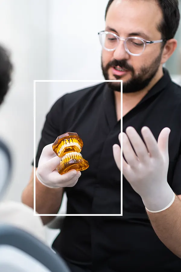 dentist-with-glasses-in-latex-gloves-holding-human-2024-11-25-13-30-08-utc